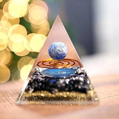 Pirâmide decorativa em resina com esfera azul e base de pedras pretas e douradas