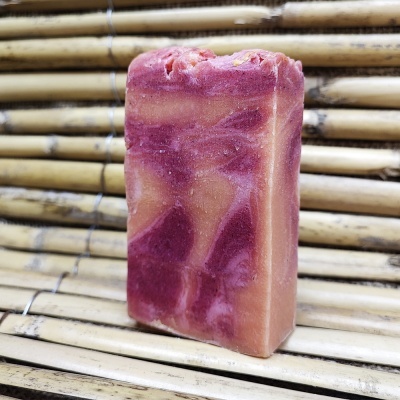 Sabonete artesanal rosa com padrões marmoreados em superfície de bamboo