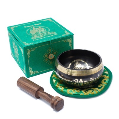 Tigela cantores tibetana preta e dourada com suporte verde bordado e malhete de madeira, junto de caixa verde com texto