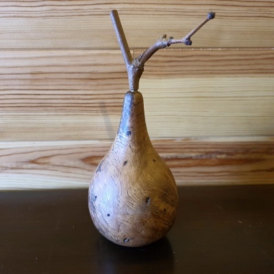 Escultura de madeira em forma de pêra com ramo seco no topo