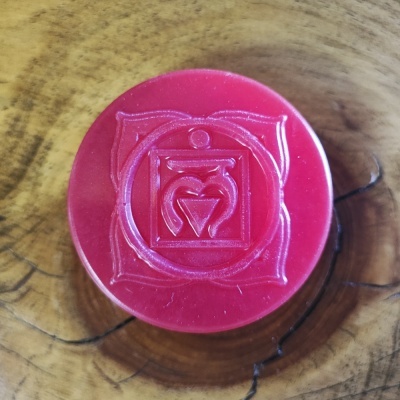 Tampa vermelha com símbolo geométrico em relevo sobre madeira clara