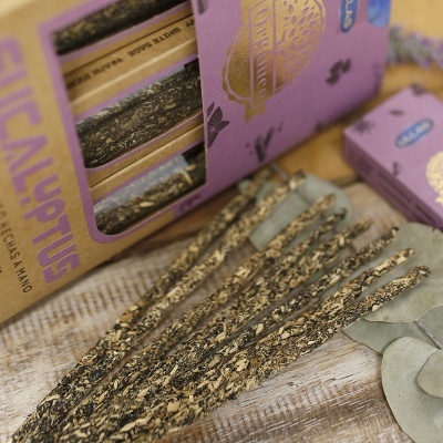 Incenso tipo pau em embalagem roxa com texto CHICALYPTUS e HECHO A MANO sobre mesa de madeira