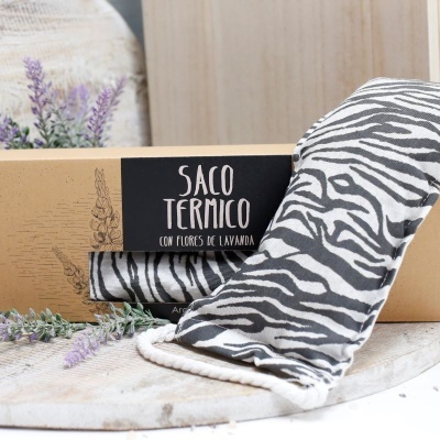 Saco térmico com padrão zebrano preto e branco ao lado da embalagem de cartão castanho com etiqueta preta