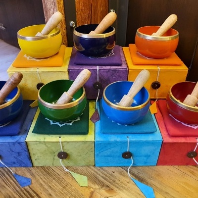 Conjunto de almofarizes em cerâmica coloridos com almofarizes de madeira sobre caixas coloridas numa superfície de madeira