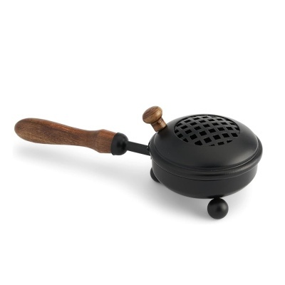 Panela de ferro preta com tampa perfurada e suporte de madeira