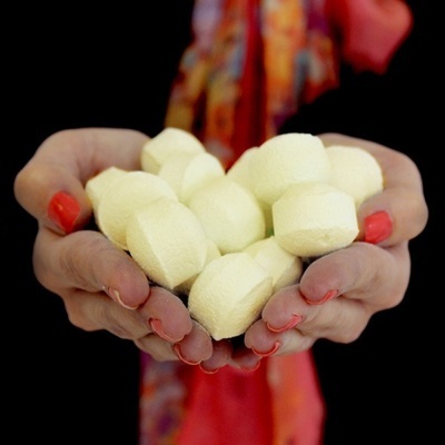 Mãos femininas segurando pães pequenos brancos redondos