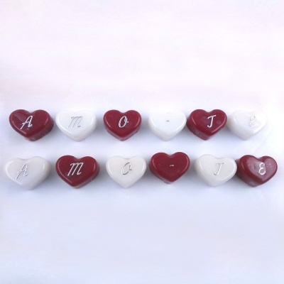 Doze corações de cerâmica vermelhos e brancos com letras desenhadas