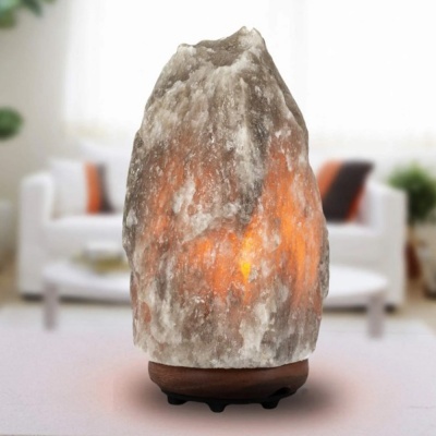 Lâmpada de sal iluminada com base de madeira num ambiente interior