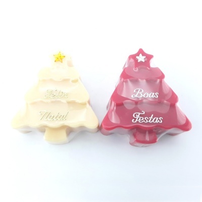 Enfeites de Natal em forma de árvores amarelo e vermelho com inscrições festivas.