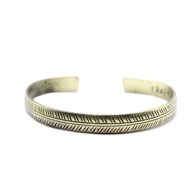 Pulseira aberta de metal prateado com padrão diagonal gravado.