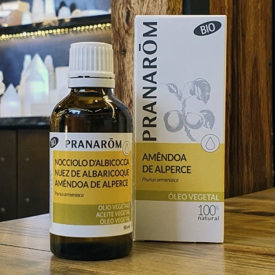 Frasco e caixa do óleo vegetal Amêndoa de Alperce Pranarôm em superfície de madeira