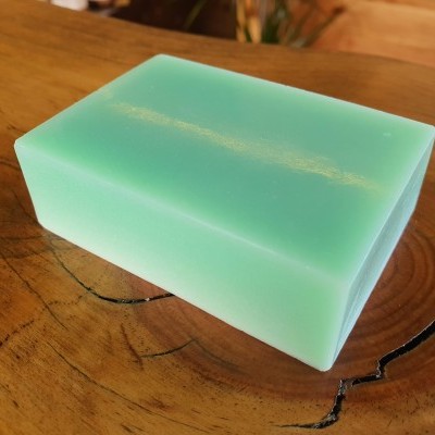 Sabão retangular verde claro sobre madeira natural