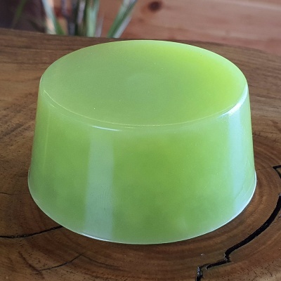 Sabonete verde translúcido sobre superfície de madeira clara