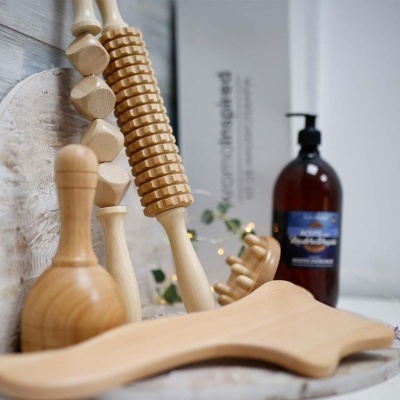 Equipamentos de massagem em madeira com frasco de líquido ao fundo