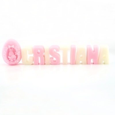 Letras decorativas formando CRISTIANA com vela em forma de ovo rosa com coelho