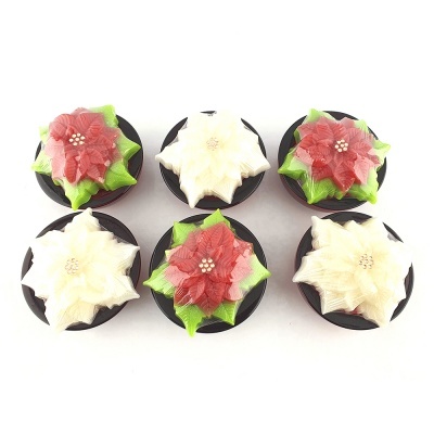 Seis velas decorativas em forma de flor de Natal em potes pretos