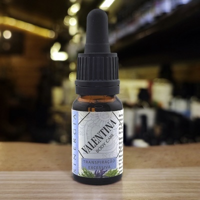 Frasco pequeno âmbar com conta-gotas preto e rótulo branco com texto Valentina Body Care, sobre mesa de madeira