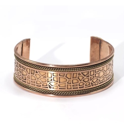 Bracelete metálico cor cobre com padrão geométrico em relevo e bordas trançadas