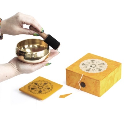 Tigela tibetana dourada com acessórios em fundo branco