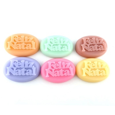 Seis sabonetes ovais coloridos com a inscrição 'Feliz Natal'