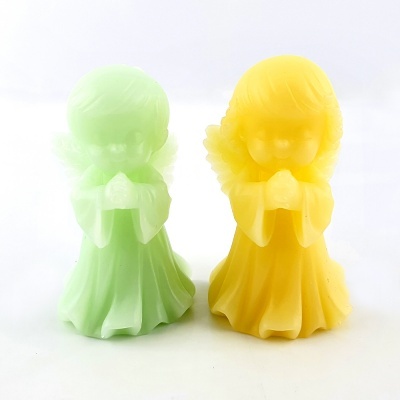 Duas velas em forma de anjo, verde claro e amarela, sobre fundo branco