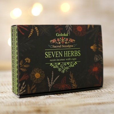 Embalagem preta com padrões florais coloridos e texto Goloka Seven Herbs Sacred Smudges