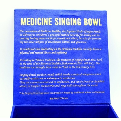 Parte interna da tampa de caixa azul com texto sobre tigela cantora de medicina