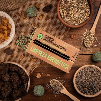 Caixa de bombita de defumação ativada em superfície de madeira com ervas secas e tecido rústico