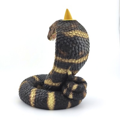 Estatueta de cascavel enrolada com escamas preto e amarelo e cone amarelo na cabeça