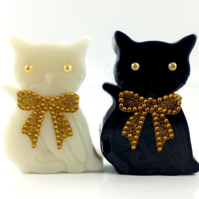 Figuras decorativas de gatos branco e preto com laços dourados brilhantes