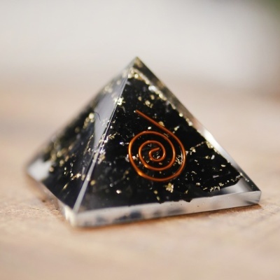 Pirâmide de resina com partículas douradas e espiral de cobre dentro