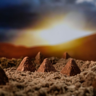 Montes cónicos de cacau em pó sobre superfície em pó marrom com fundo desfocado colorido