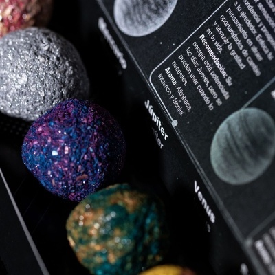 Bolas decorativas coloridas e embalagem preta com texto em espanhol