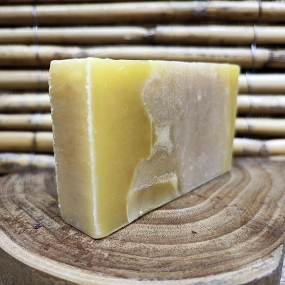 barra de sabão amarelo e bege sobre madeira com fundo de bambu