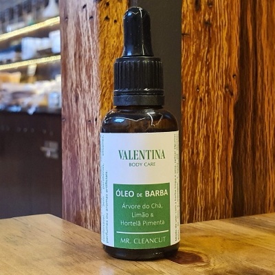 Frasco de óleo de barba Valentina Body Care com conta-gotas sobre mesa de madeira