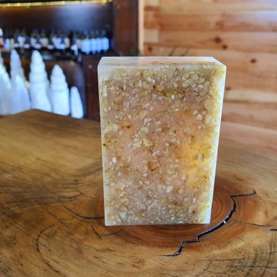 Sabonete artesanal granulada bege na madeira com sabonetes brancos ao fundo