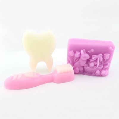 Sabonetes coloridos em formas de dente, escova de dentes e sabonete retangular com relevo