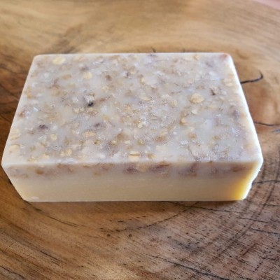 Barra de sabão com aveia sobre superfície de madeira