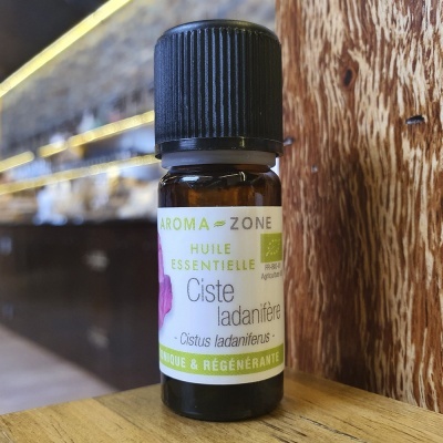 Frasco pequeno de óleo essencial Ciste ladanifère da Aroma Zone sobre madeira