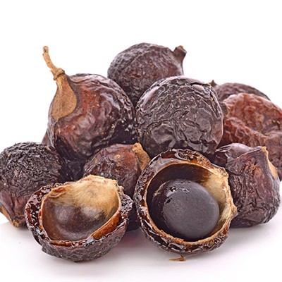 sementes de noz de sabão castanhas escuras com casca enrugada, algumas partidas mostrando sementes internas