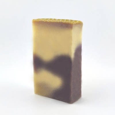 Sabonete retangular amarelo e castanho com textura ondulada no topo