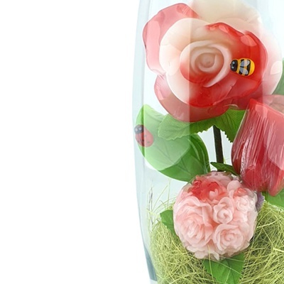 Arranjo de flores artificiais vermelhas e rosa em copo de vidro com detalhes de abelha e joaninha