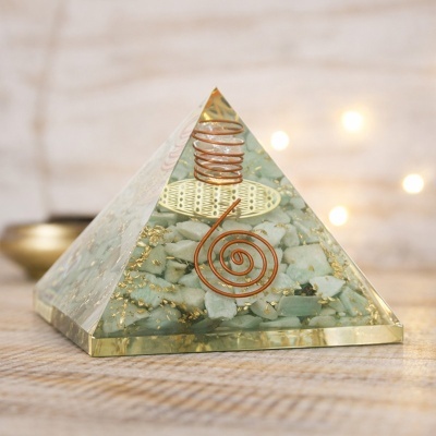 Pirâmide decorativa com pedras verdes, fios de cobre e detalhes dourados