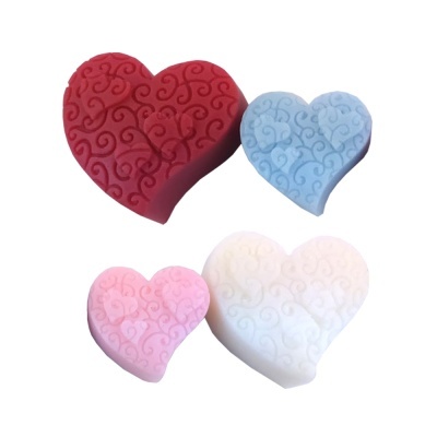 Almofadas em forma de coração com padrão de arabescos em quatro cores.