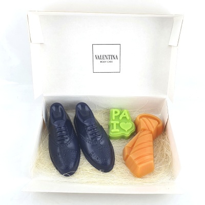 Caixa aberta com artigos em formato de sapatos e peça com texto 'PA I ❤️'