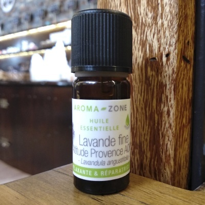 Frasco de óleo essencial de lavanda fina Aroma-Zone em superfície de madeira