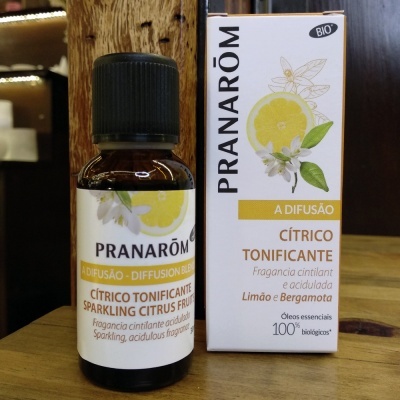 Frasco de óleo essencial e caixa PRANARÔM CÍTRICO TONIFICANTE com design de limão e flores