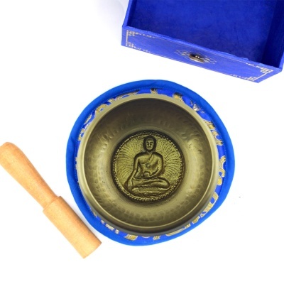 Taça tibetana dourada com padrão de Buda dentro, almofada azul e bastão de madeira