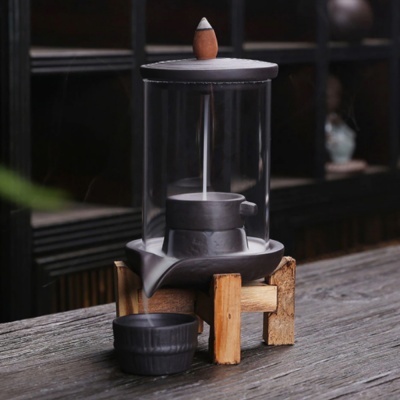 Recipiente de cerâmica preta com vidro transparente e suporte de madeira sobre mesa