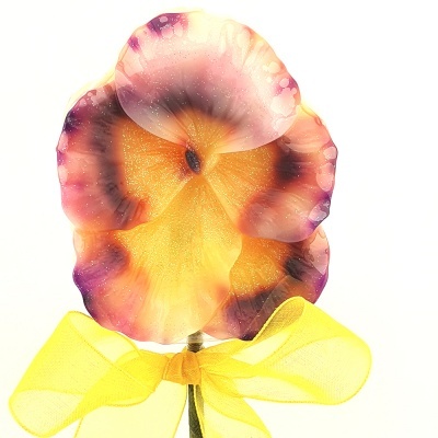 Flor artificial colorida com laço amarelo